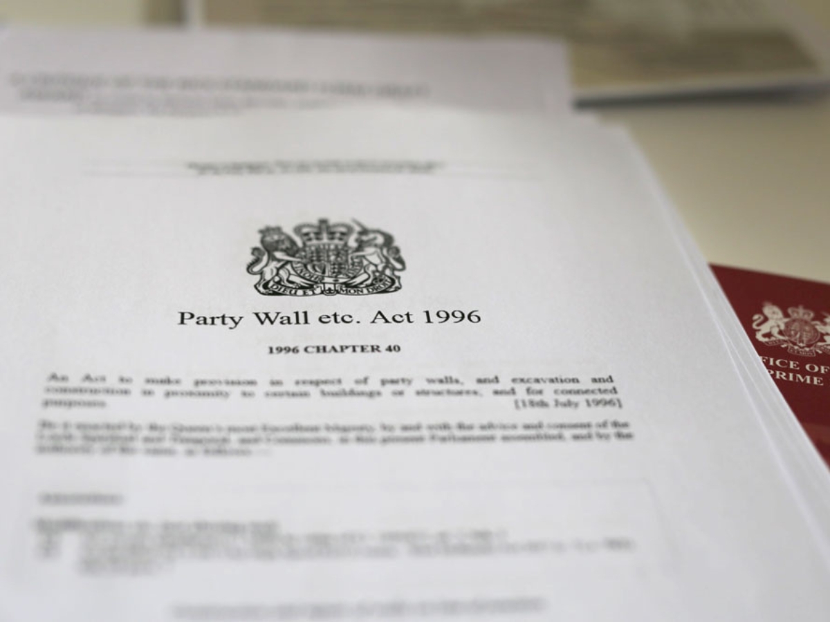 Close-up of printed document titled "Party Wall etc. Act 1996," featuring the UK's royal crest and legislative details.