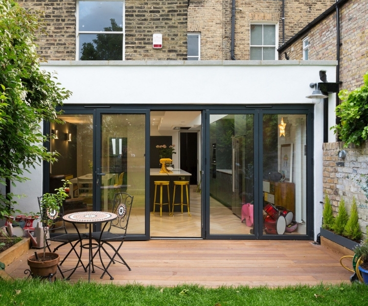 Modern flat-roof side extension with large glass doors and garden.