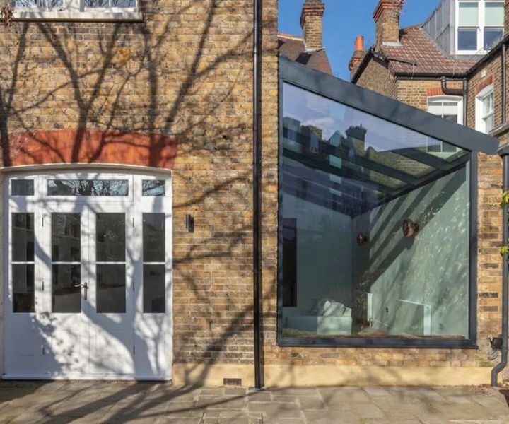 Modern glass side extension with angular design and natural lighting.