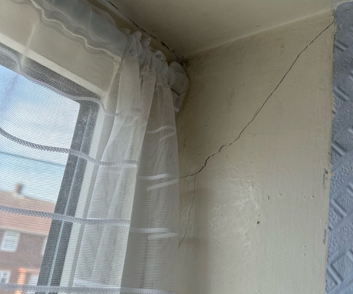 Fine crack on interior wall corner near window frame.