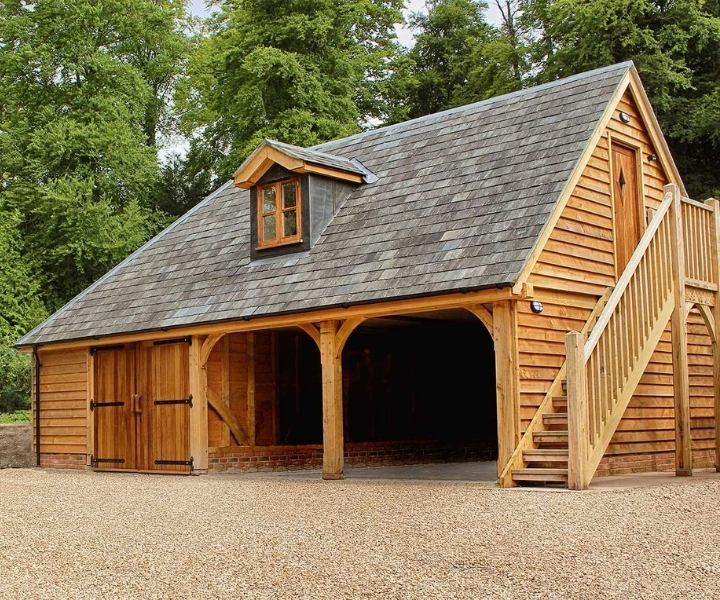 Wooden outbuilding with garage, upstairs room, and external staircase.