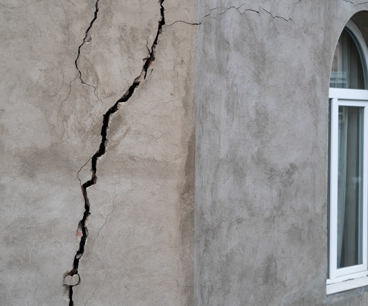 Large vertical crack on exterior corner of building wall.