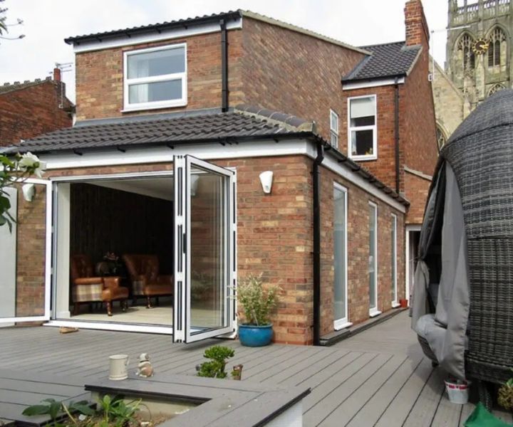 Bright side return extension with open bi-fold doors and decking.