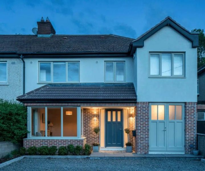 Elegant two-storey side extension with modern front door and windows.
