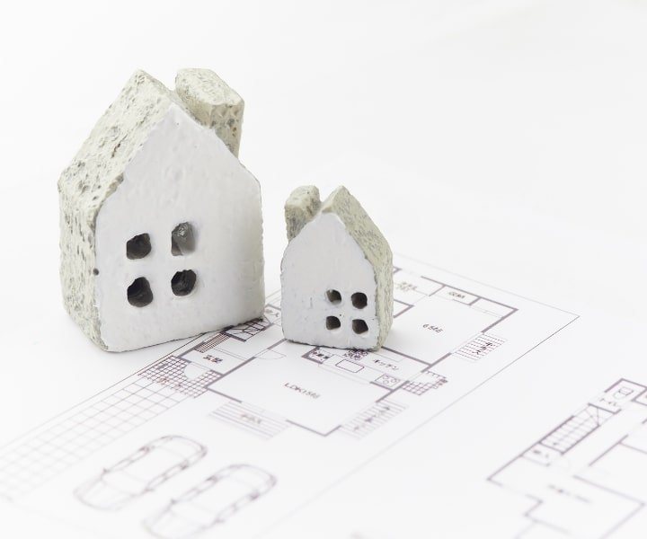 Miniature house models on top of architectural blueprint plan.