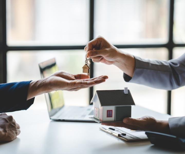 Handing over house key during property purchase agreement.